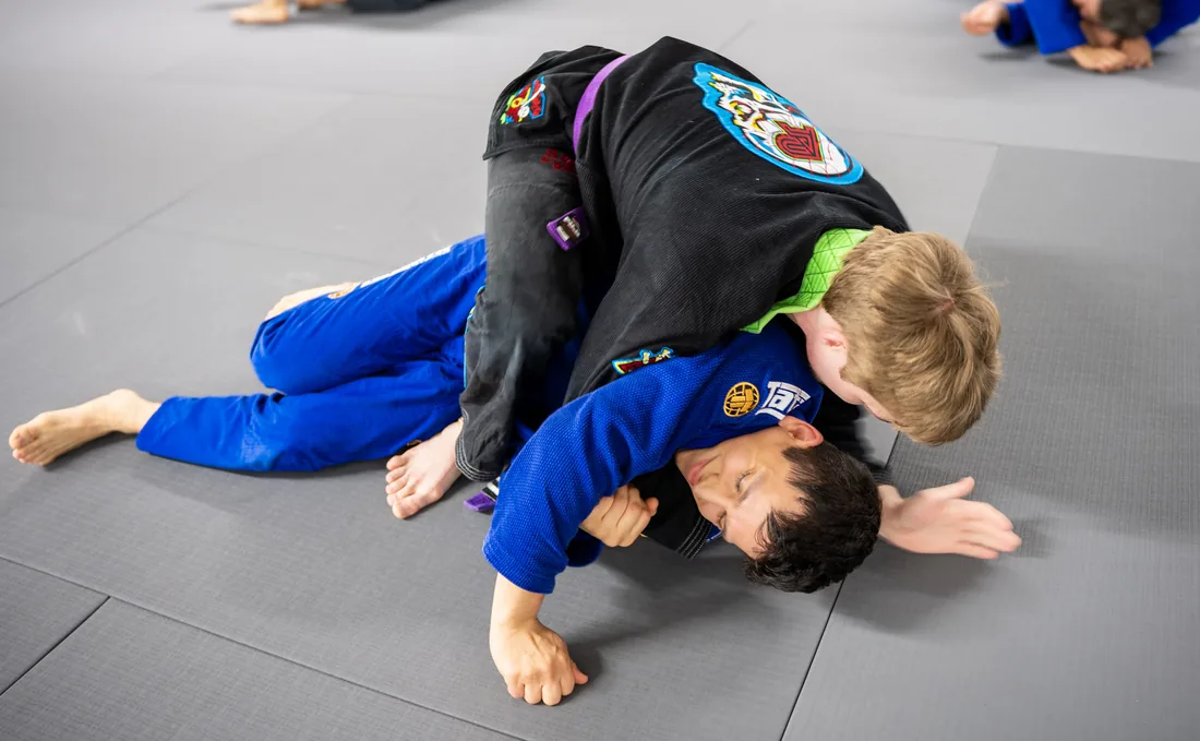Two Revolution Dojo Houston Brazilian Jiu-Jitsu students practicing ground control in gis